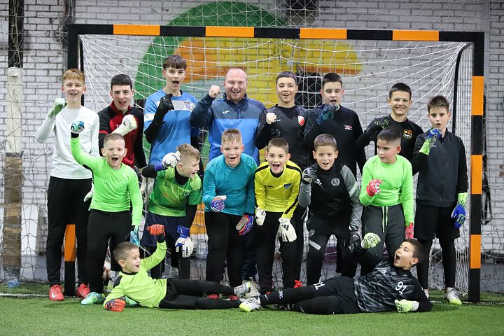 Golmani škole zajedno ispred gola, podignutih ruku i nasmejani